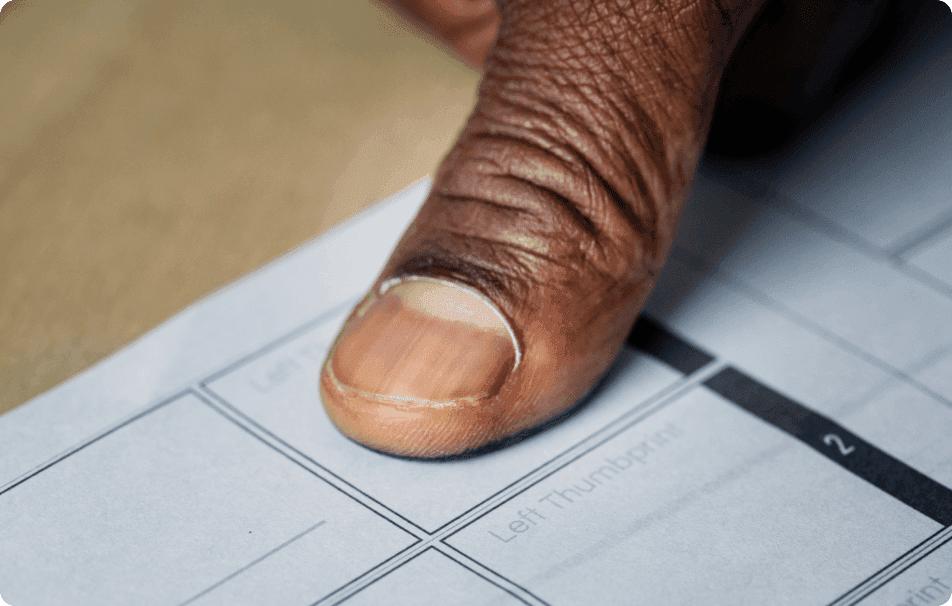 A close-up of a thumb pressed onto a ballot paper beside a box marked “Left Thumbprint”.