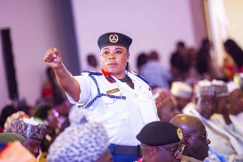 A uniformed officer standing to speak from the floor at the Northwest Regional Conference, one hand raised mid-gesture, delegates seated around her.